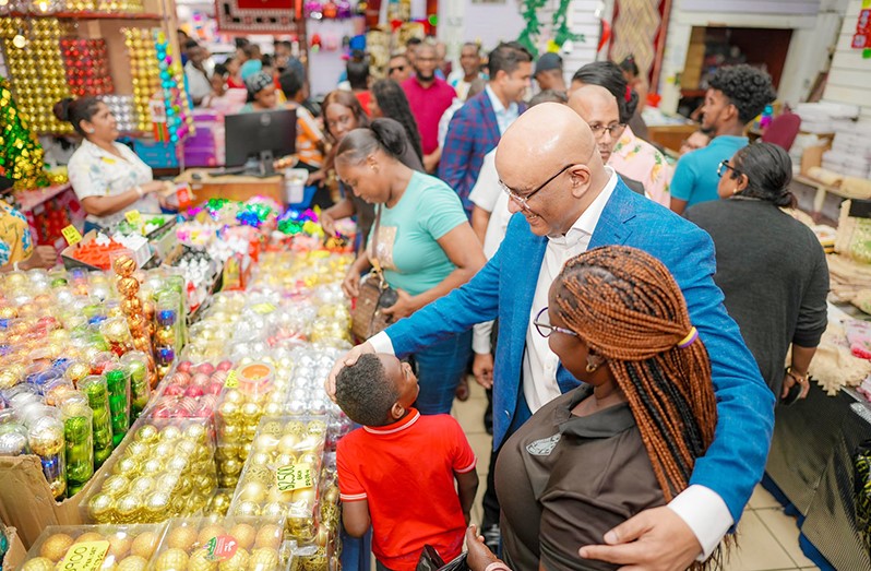 Dr Bharrat Jagdeo holding hand with Customers in market place