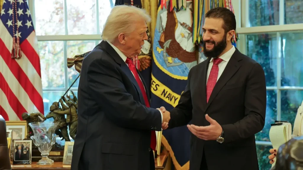 US President Donald Trump (L) shaking hands with Syria's President Ahmed al-Sharaa at the White House in Washington DC.