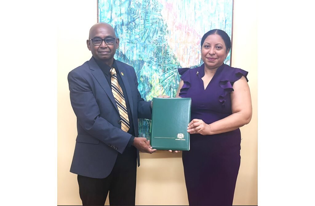 Vice-Chancellor of the University of Guyana, Prof Paloma Mohamed Martin, presenting the instruments of office to Prof. Randy Persaud
